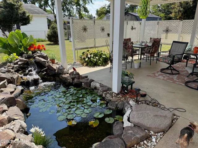 a view of a chair and table in backyard of the house