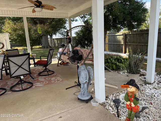 a view of backyard with wooden fence and large trees