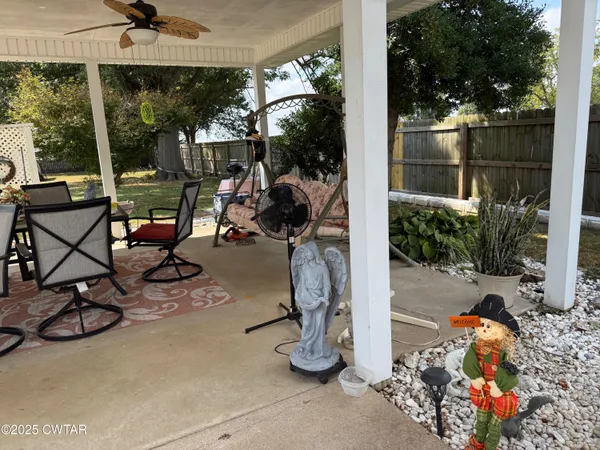 a view of backyard with wooden fence and large trees