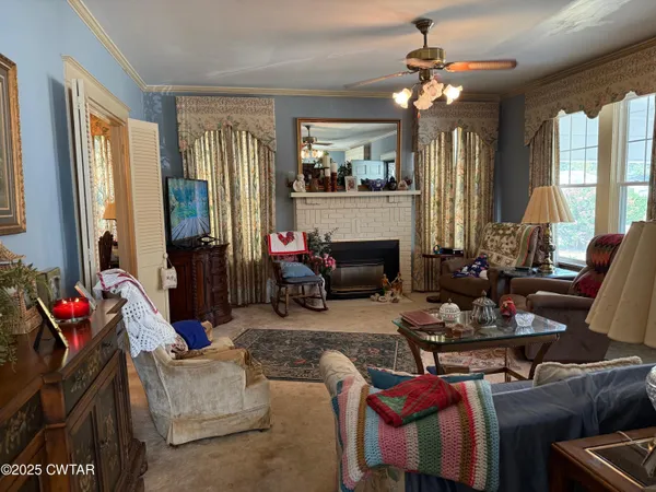 a living room with furniture fireplace and a large window