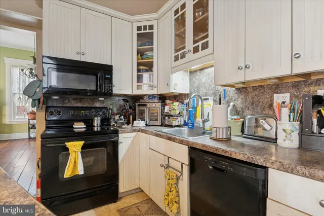 a kitchen with granite countertop a stove sink and cabinets