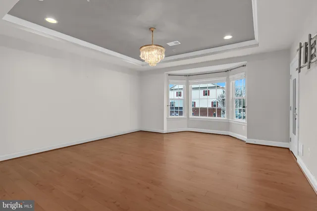 a view of an empty room with a chandelier fan