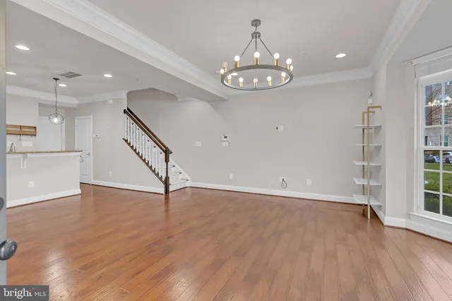 an open kitchen with wooden floor and stainless steel appliances