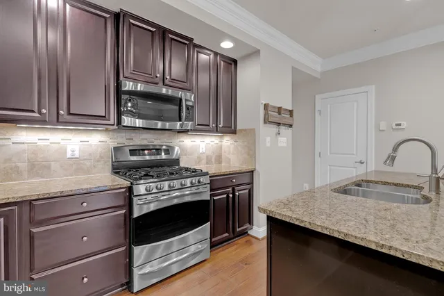 a kitchen with stainless steel appliances granite countertop a sink stove and refrigerator