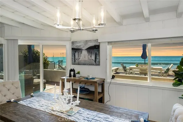 a dining room with wooden floor and a floor to ceiling window