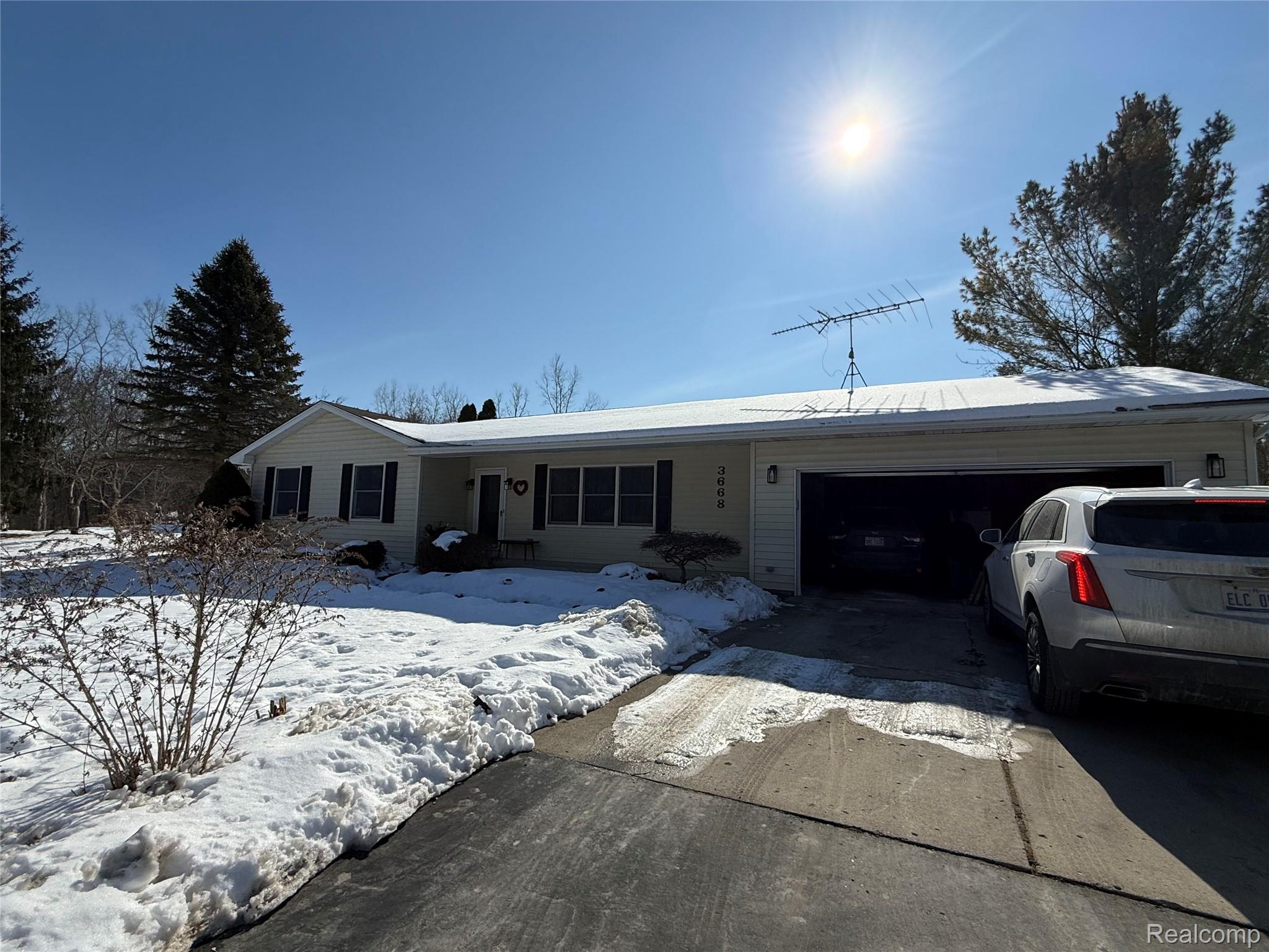 3668 East Allen Road Howell, MI 48855 - Photo 1 of 18 Ranch-style residence featuring light-colored siding, dark window shutters, and an attached two-car garage