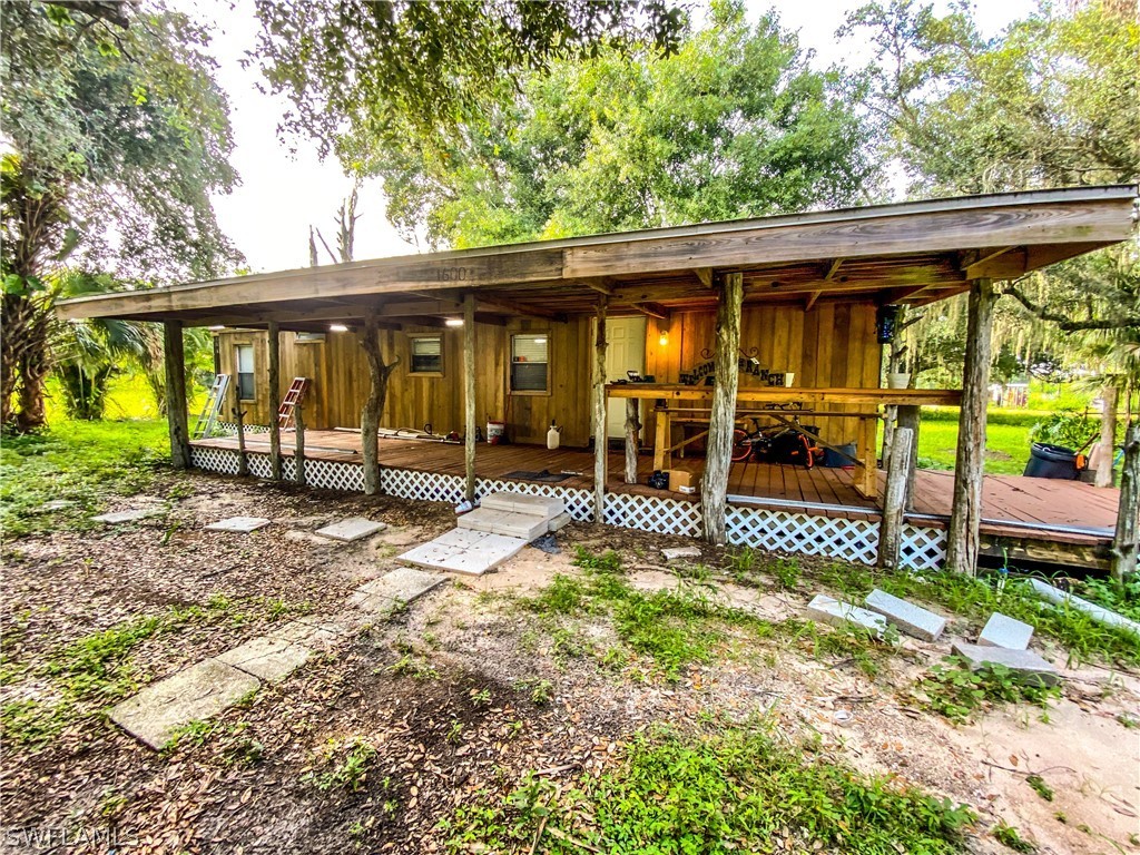 1600-1800 G Road LaBelle, FL 33935 - Photo 5 of 10 a view of a patio with table and chairs under an umbrella with a small yard