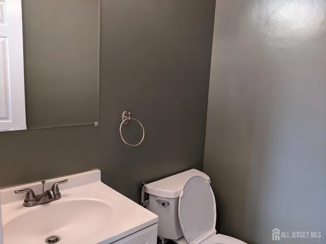 a bathroom with a sink a toilet and a mirror