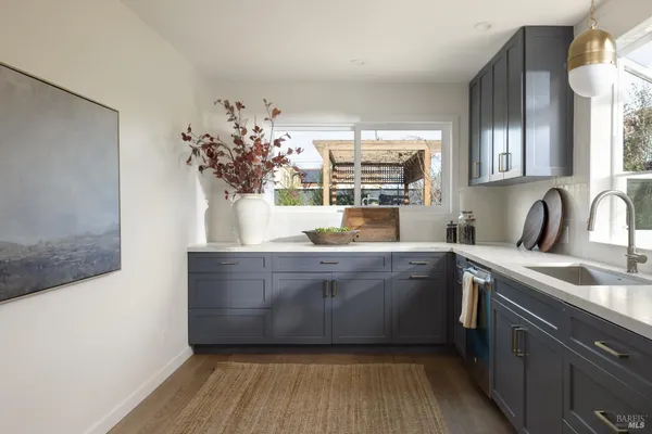 a room with a sink and dishwasher with wooden floor