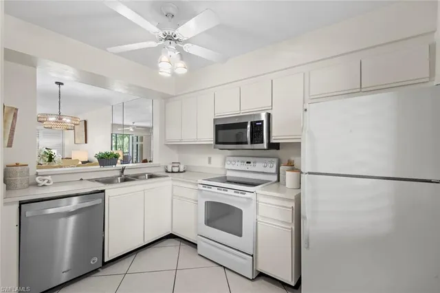 a kitchen with white cabinets stainless steel appliances and a refrigerator