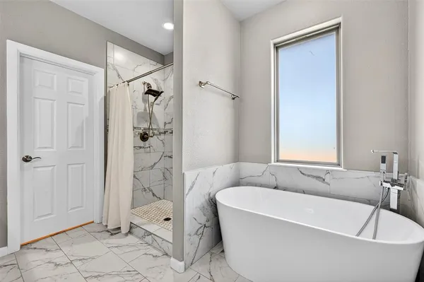 a white bath tub sitting next to a white toilet