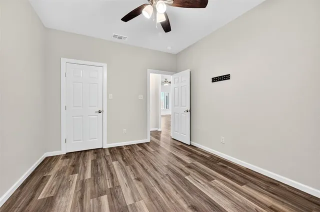 a view of an empty room with wooden floor