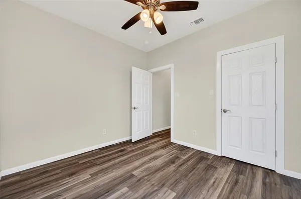 a view of empty room with wooden floor