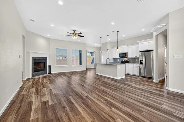 a view of kitchen with cabinets appliances and wooden floor