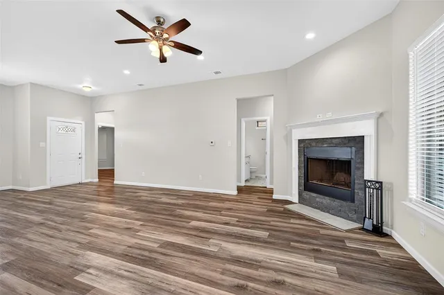 a view of an empty room with a fireplace and a window