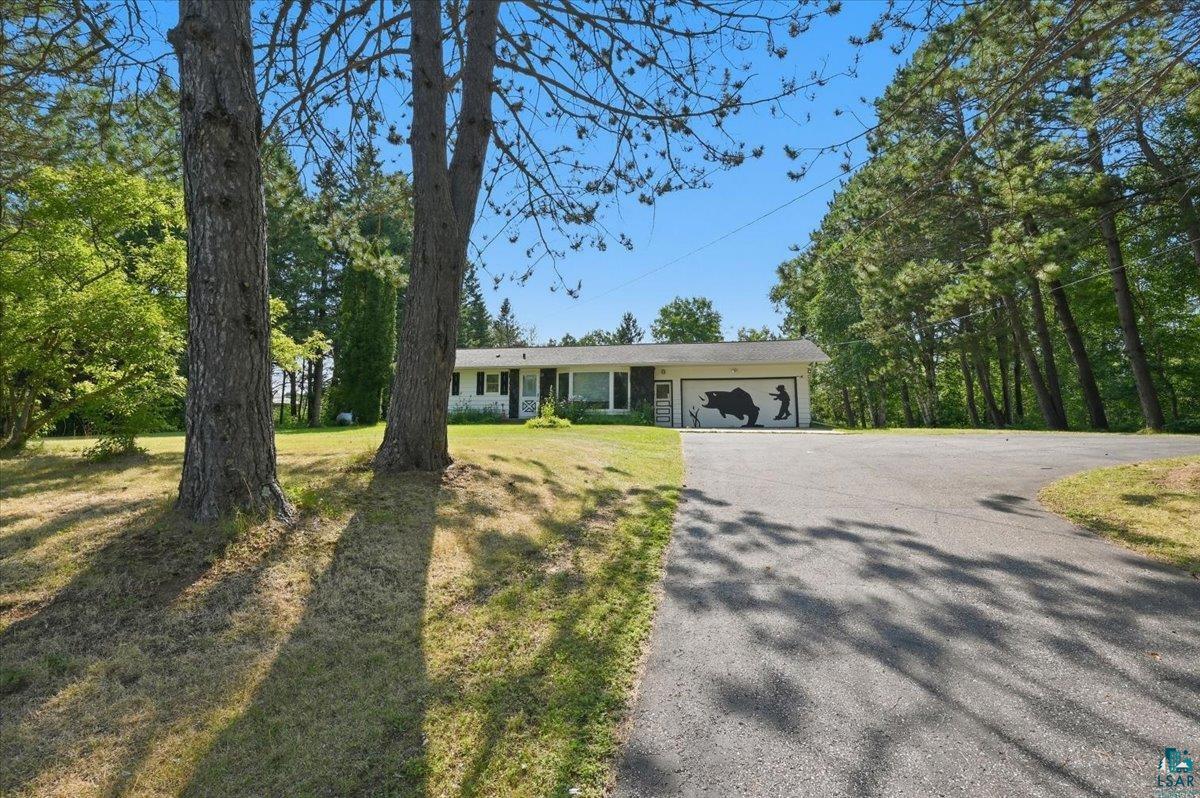 3587 Stebner Road Hermantown, MN 55811 - Photo 22 of 30 Exterior with mature trees, a paved driveway, attached garage, and surrounding greenery