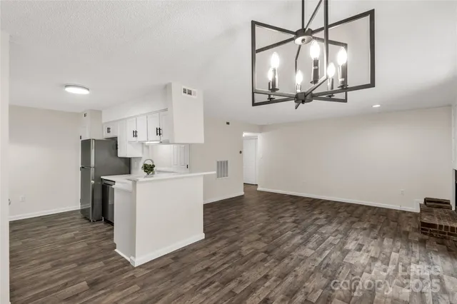 a kitchen with kitchen island a stove a refrigerator and a wooden floor