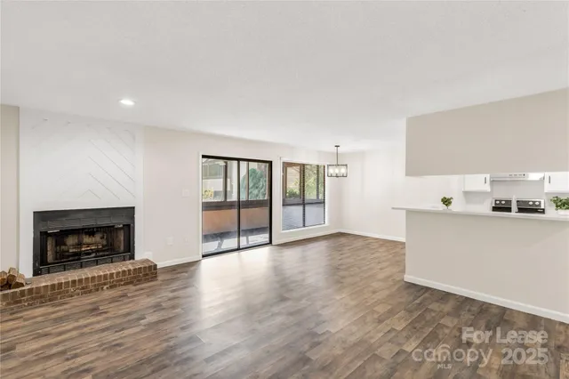 a view of empty room with wooden floor and fireplace