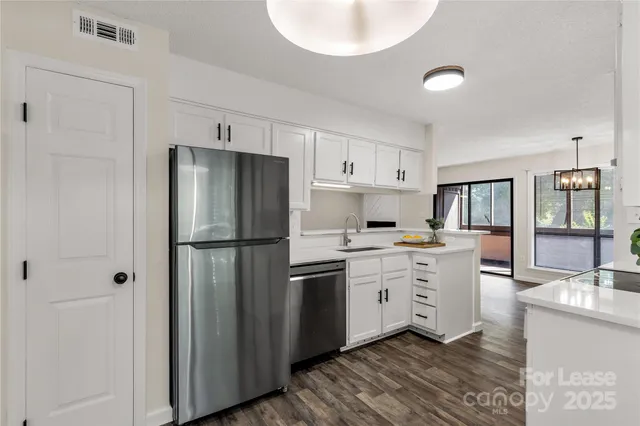 a kitchen with stainless steel appliances a refrigerator sink and cabinets