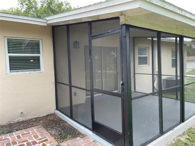 an empty room with windows and ceiling fan