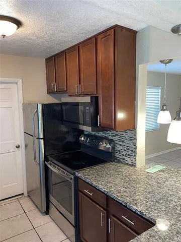 a kitchen with granite countertop sink and cabinets