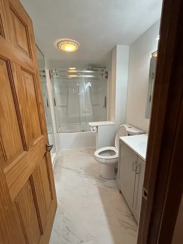 a bathroom with a granite countertop sink toilet and shower