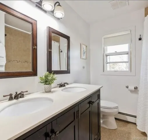 a bathroom with a granite countertop sink a toilet and a mirror