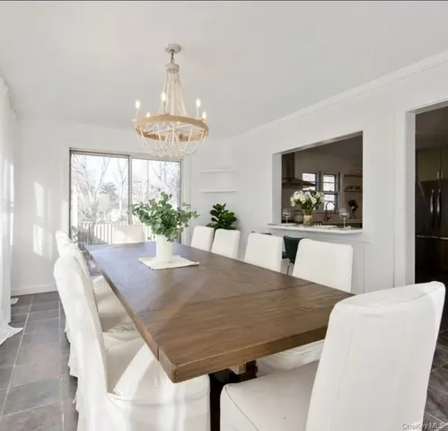 a view of a dining room with furniture a chandelier and wooden floor