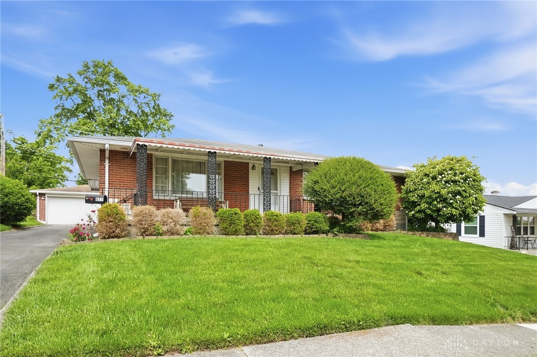 877 Woodhill Road Riverside, OH 45431 - Photo 2 of 42 This charming residence features a classic brick exterior and a well-manicured lawn, offering inviting curb appeal.