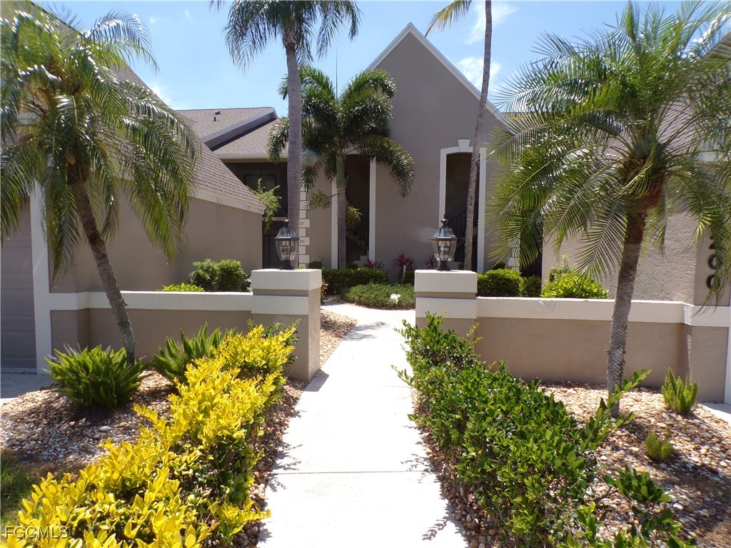 16200 Kelly Cove Drive, Unit 215 Fort Myers, FL 33908 - Photo 1 of 46 a front view of a house with a yard and a garden