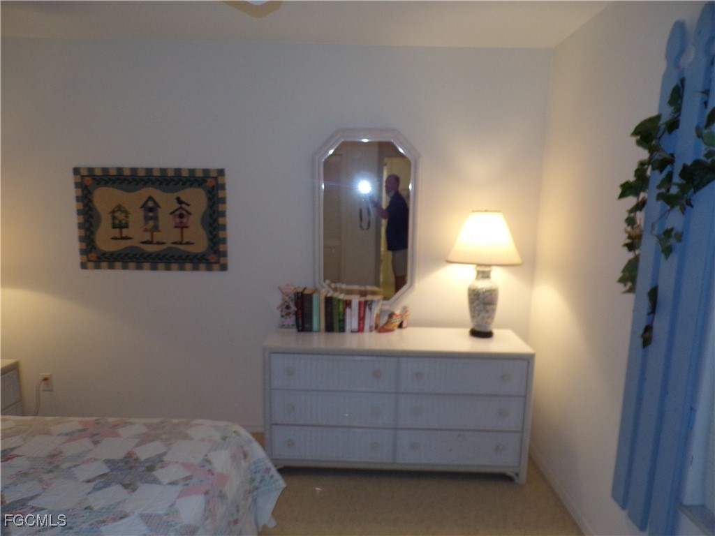 16200 Kelly Cove Drive, Unit 215 Fort Myers, FL 33908 - Photo 20 of 46 a bedroom with a bed and a lamp on dresser