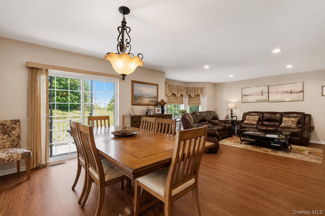 64 Roma Orchard Road Peekskill, NY 10566 - Photo 15 of 40 Spacious dining area featuring a wood-finish dining table, chandelier lighting, and a sliding glass door providing outdoor access