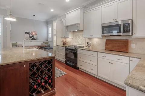 a kitchen with stainless steel appliances granite countertop a sink a stove a microwave and wooden cabinets