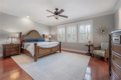 a spacious bedroom with a bed a table and a chandelier