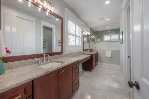 a bathroom with a granite countertop sink a large mirror and a bathtub