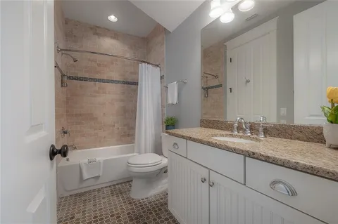 a bathroom with a granite countertop sink toilet and shower