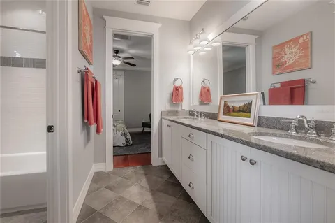 a en suite bathroom with a granite countertop sink and a mirror