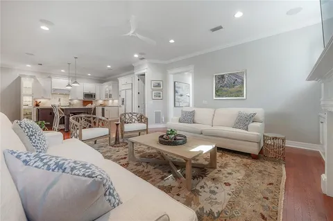 a living room with furniture and a view of kitchen