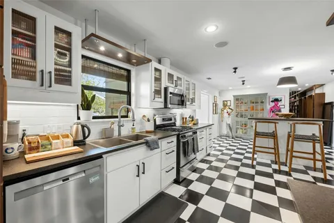 a kitchen with stainless steel appliances kitchen island granite countertop a sink and cabinets
