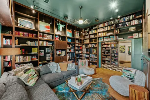 a living room with lots of furniture and a book shelf