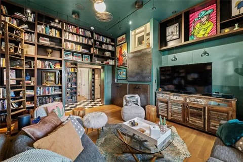 a living room with furniture a bookshelf and a book shelf