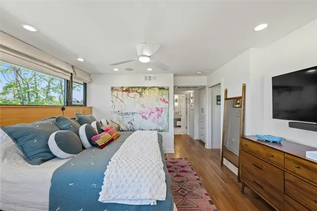 a bedroom with a bed and a dresser next to a window