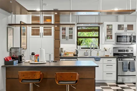 a kitchen with stainless steel appliances granite countertop a stove a sink and a refrigerator