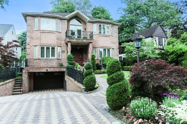 a front view of a house with a garden and plants