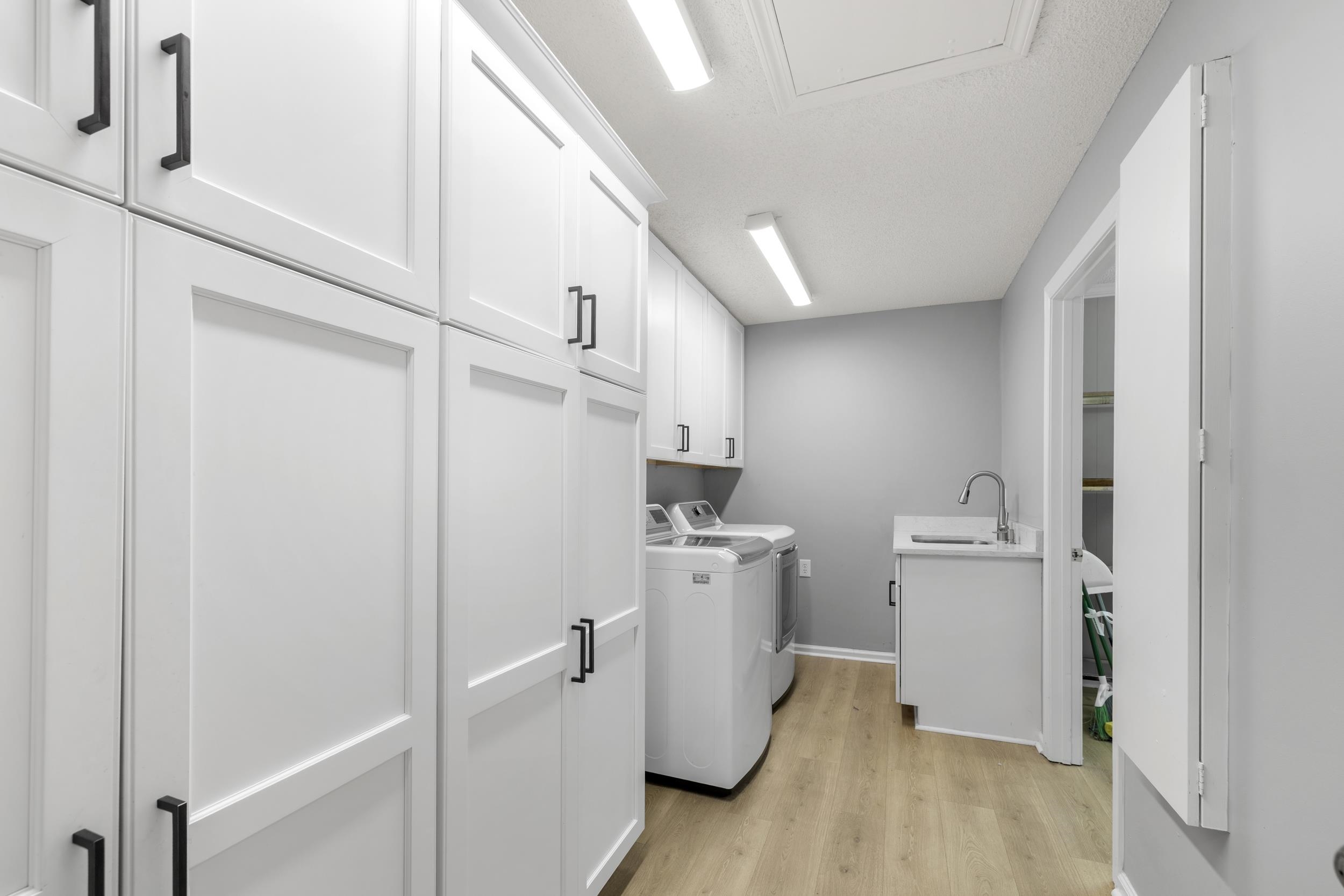 460 Woodbridge Road Somerville, TN 38068 - Photo 23 of 40 Laundry area with separate washer and dryer, light wood-type flooring, and cabinet space