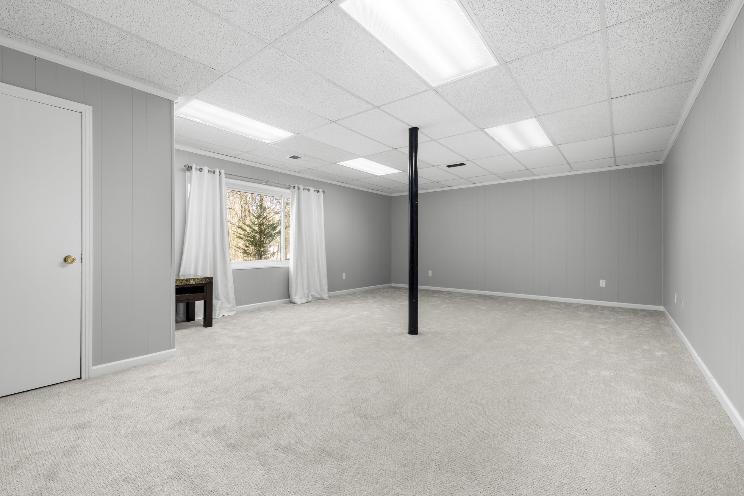 460 Woodbridge Road Somerville, TN 38068 - Photo 27 of 40 Basement featuring a paneled ceiling, light colored carpet, and wood walls