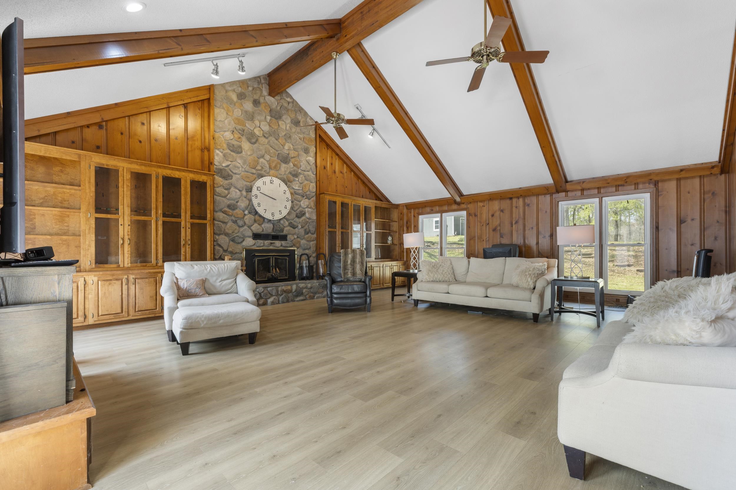 460 Woodbridge Road Somerville, TN 38068 - Photo 7 of 40 Family room featuring wood walls, wood finished floors, a stone fireplace, and track lighting