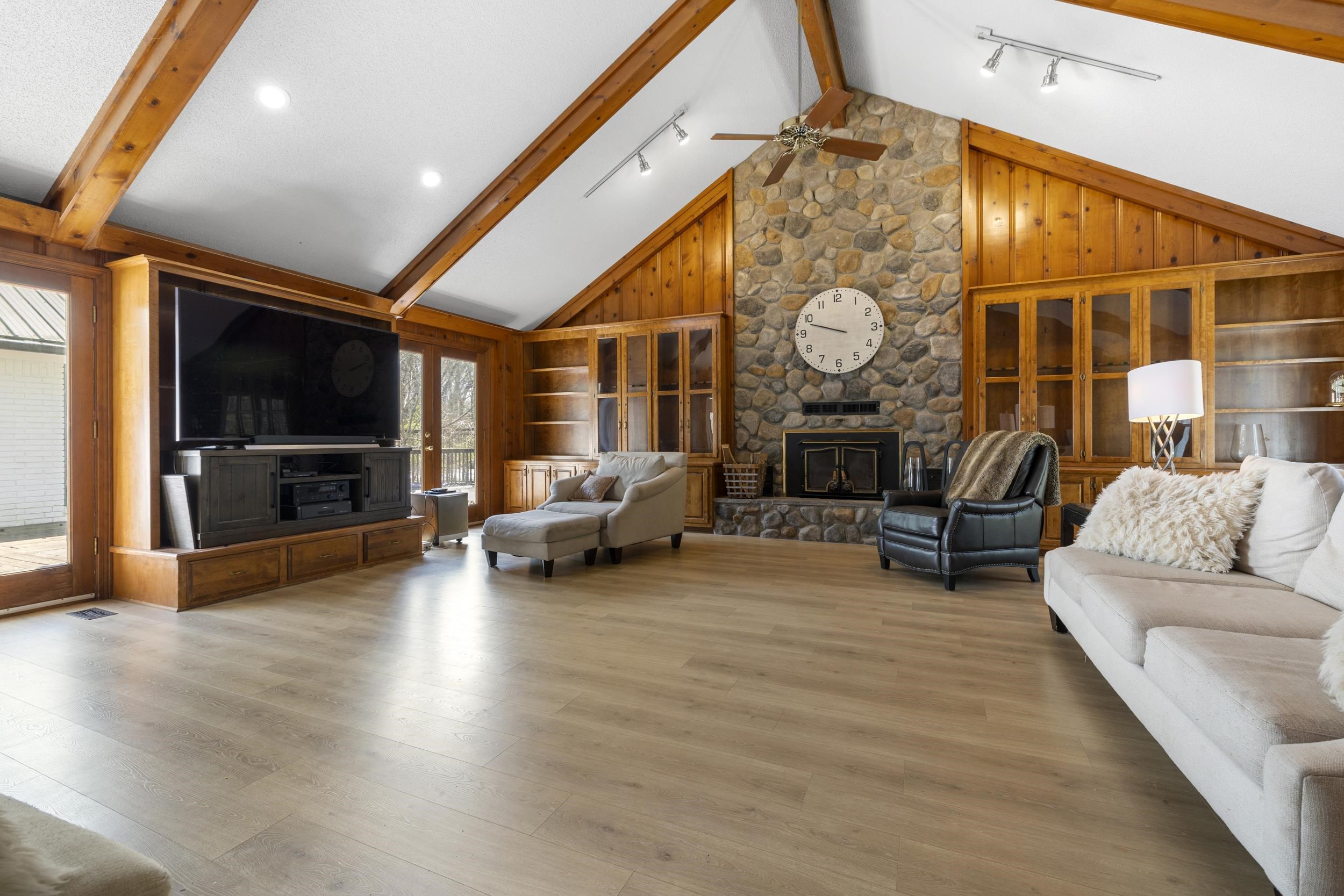 460 Woodbridge Road Somerville, TN 38068 - Photo 8 of 40 Family room featuring rail lighting, a stone fireplace, wood walls, wood finished floors, and ceiling fan