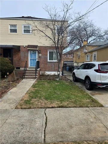 a view of a car parked in front of a brick house