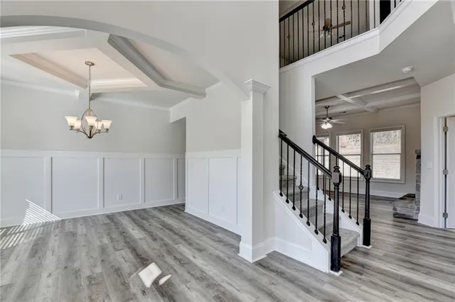 a view of staircase with wooden floor and pendant lights